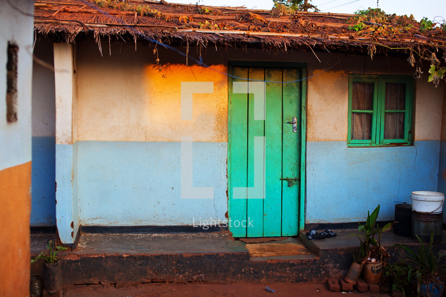 A modest house with a green door in Malawi, Africa. 