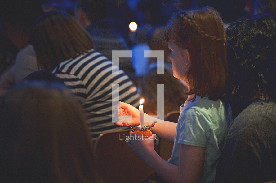 holding candles at a worship service 