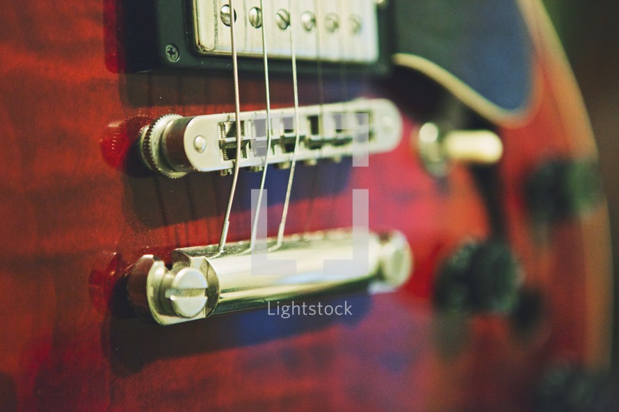Close up of the bridge, saddle and strings of a guitar.