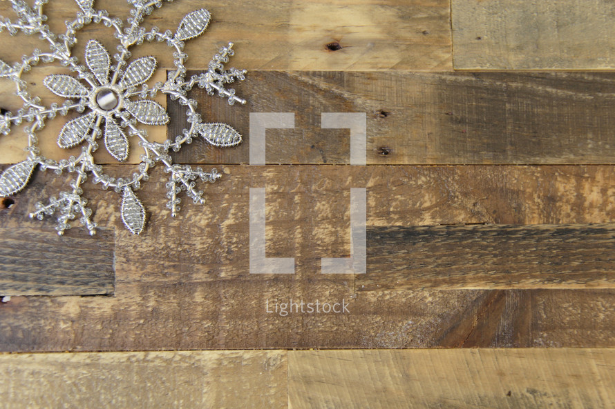 snowflake in a corner on a wood floor background