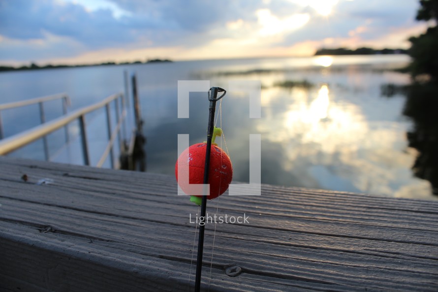 a fishing pole at a lake pier 