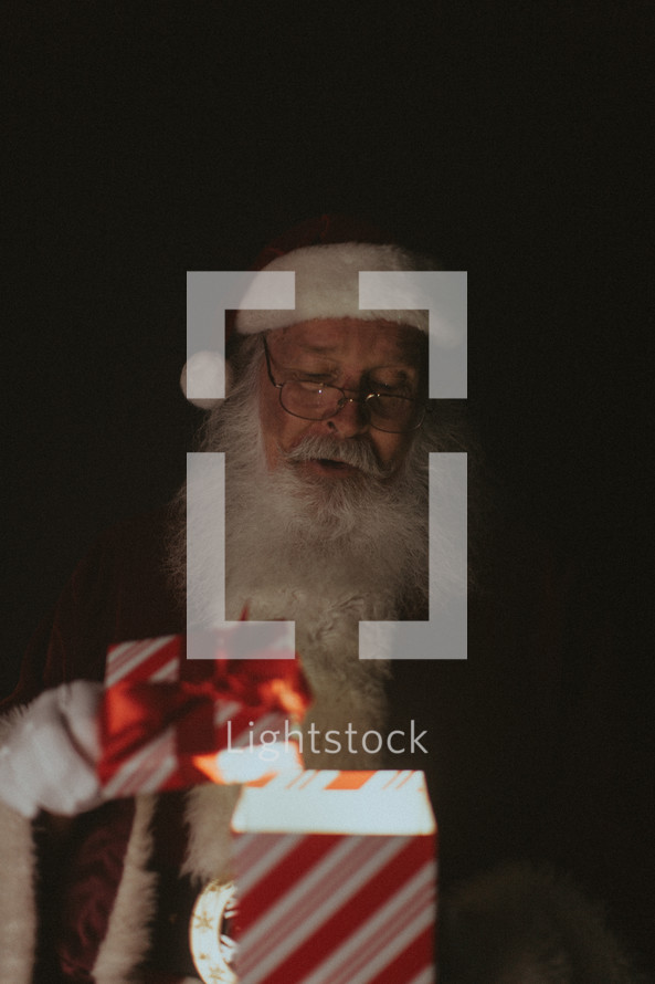 Santa holding a glowing gift 