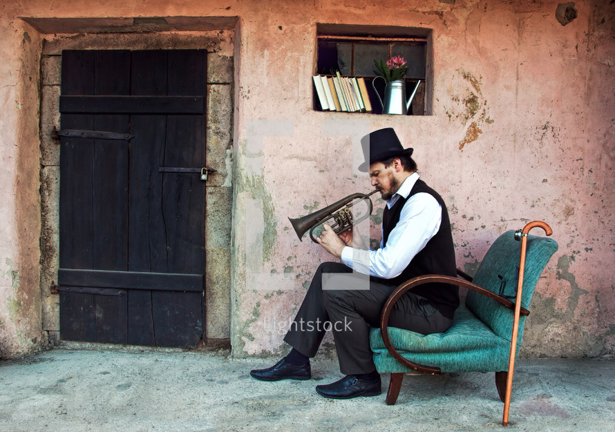man sitting in a chair playing a trumpet 