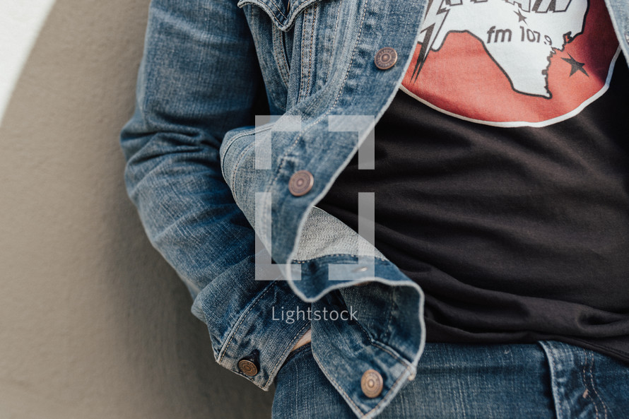 torso of a man in a denim jacket and blue jeans 