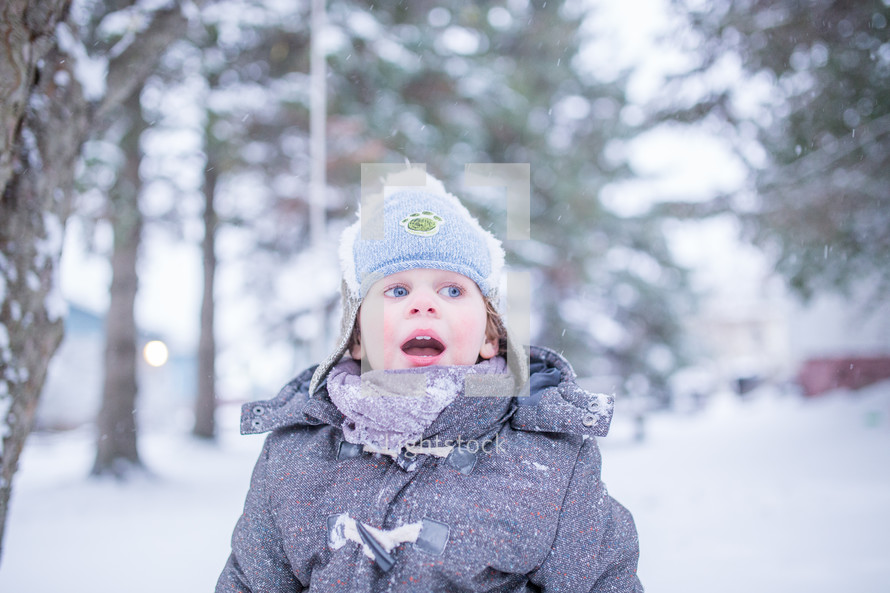a boy child playing outdoors in snow 