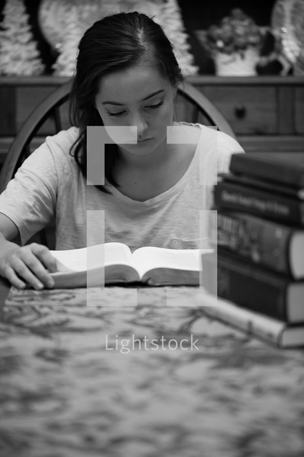 a teen girl studying at a table 