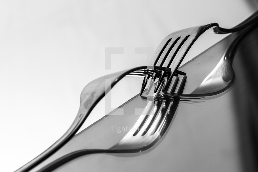 A black and white close-up of connected forks. Abstract