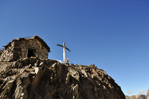 a cross shrine on a rocky peak 