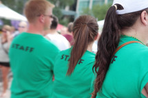 men and women in green staff t-shirts 
