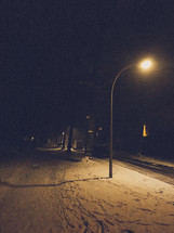 street light over a snowy path 