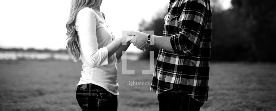 Young couple holding hands looking at each other
