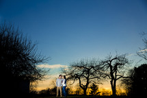 couple standing together outdoors at dusk 