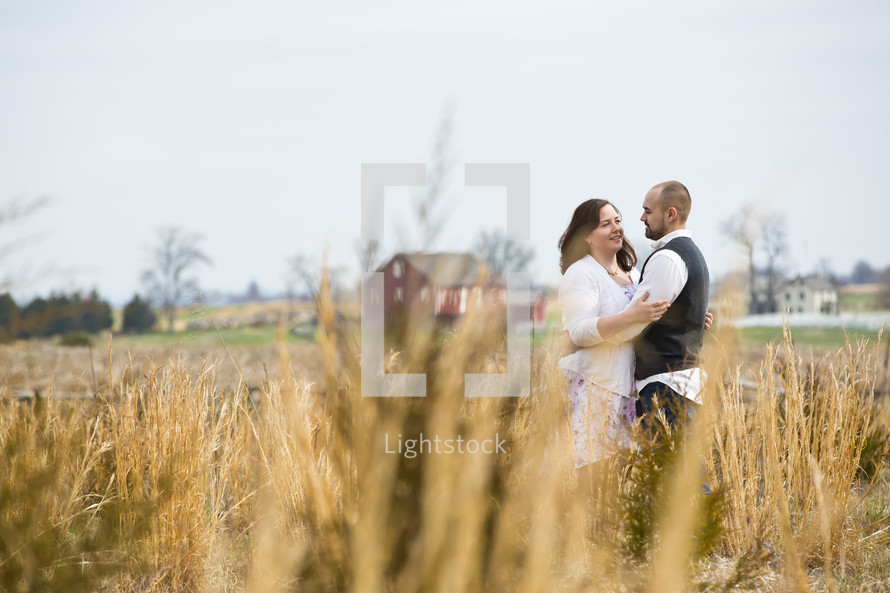 couple standing in a field hugging