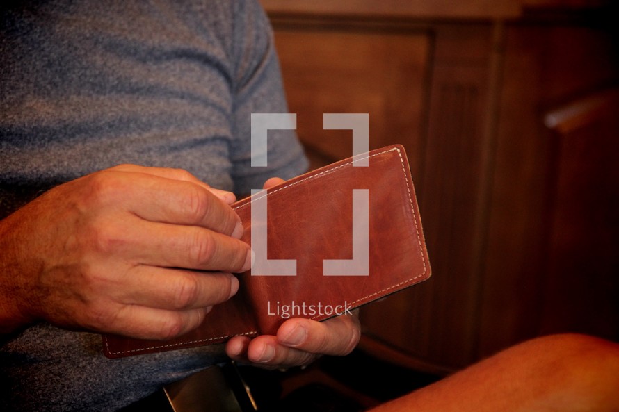 a man looking in his wallet 