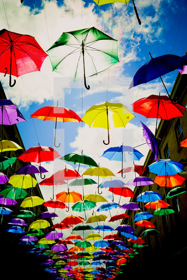 rainbow colored umbrellas over a walkway 