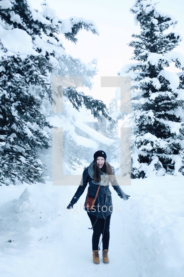 a happy woman standing in snow 