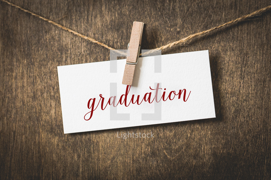 word graduation on white card stock hanging on a clothesline of twine