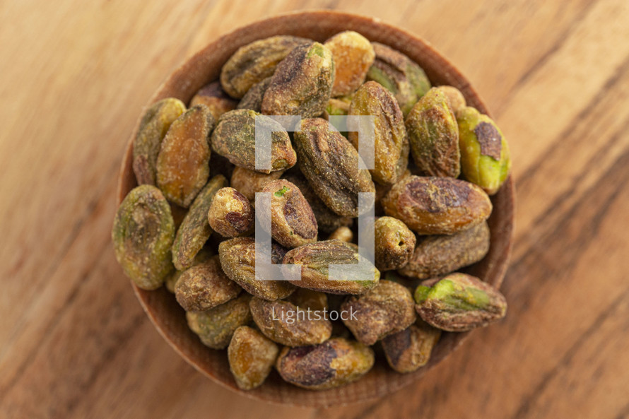 Roasted and Salted Pistachios without Shells on a Wood Table