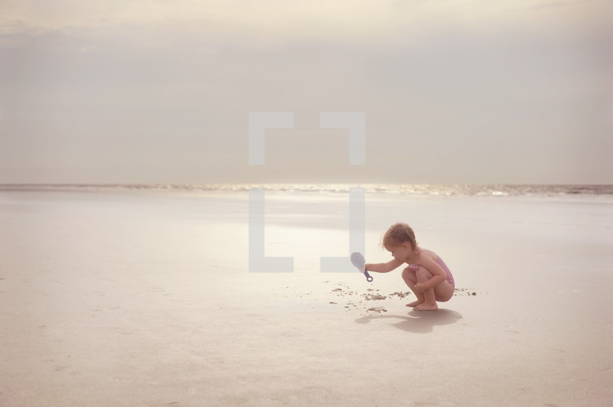 child playing in the sand on a beach 