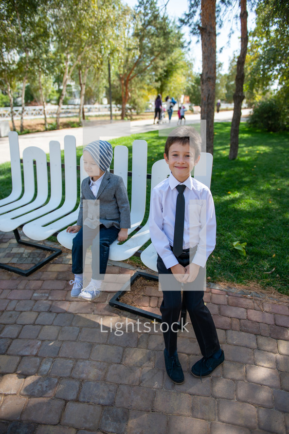 brothers sitting on a bench at a park 