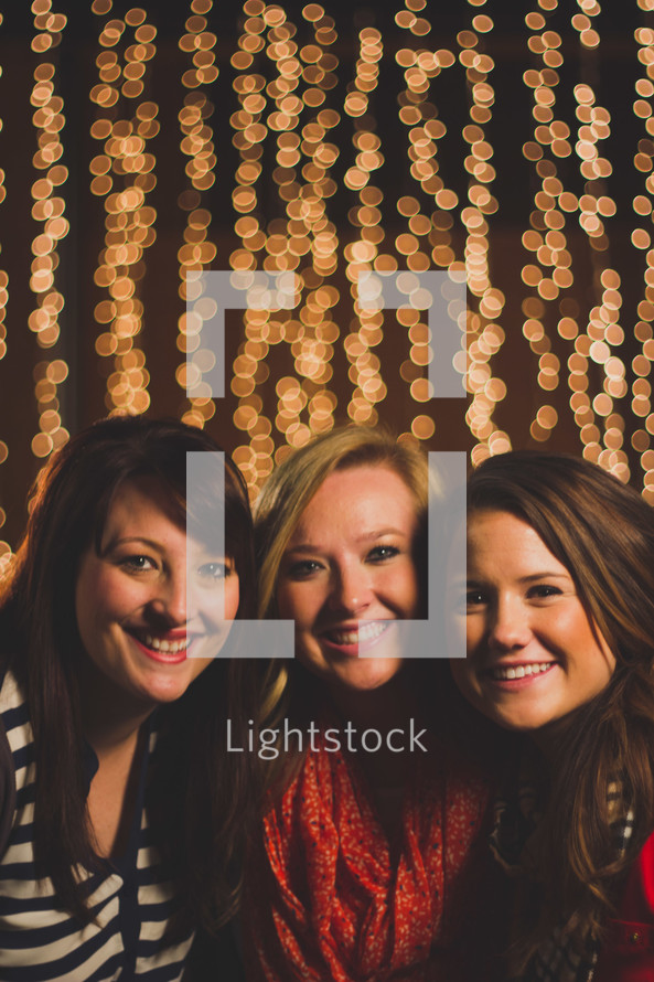 Smiling women with sparkling lights.
