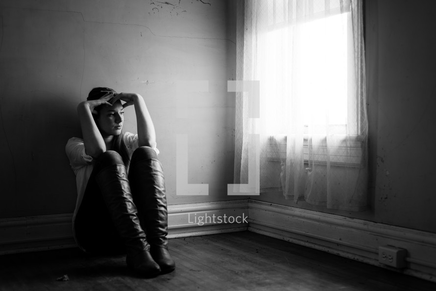 teen girl sitting in an empty room 