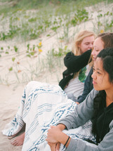 teen girls sitting on the dunes on a beach 