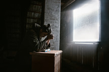 a man praying with head bowed over a Bible 