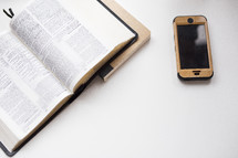 Bible, journal, and cellphone on a white table 