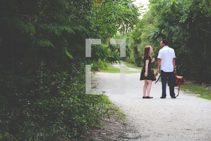 a couple standing on a dirt road 