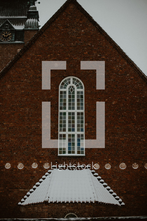 snow on a brick church roof 