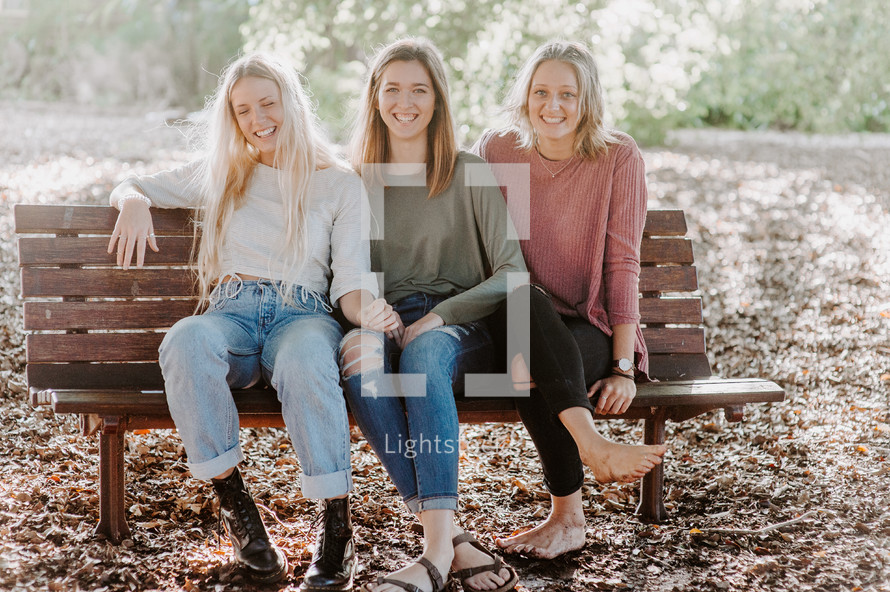 three women sitting on a bench 