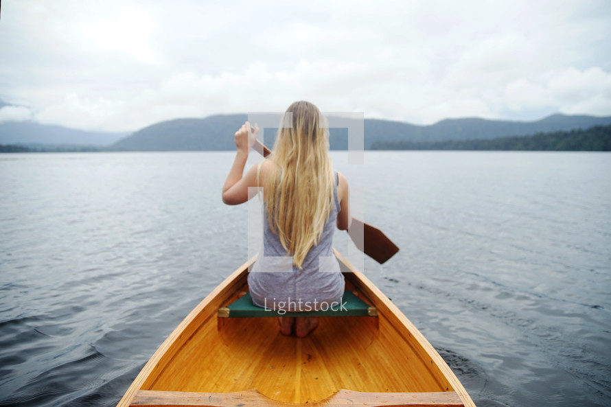 a woman paddling a canoe 