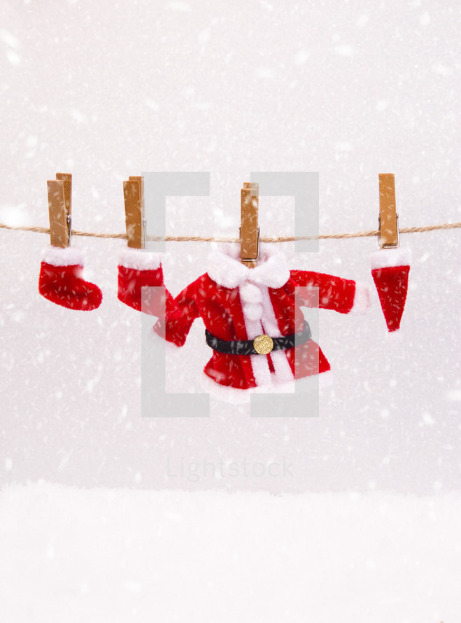 Santa suit and Christmas stockings on a clothesline in the snow 