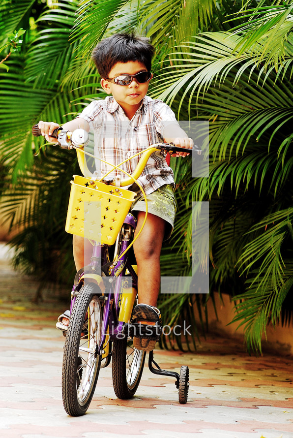 child riding a bike with training wheels 