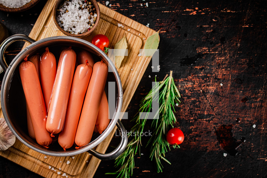 Delicious sausages boiled on the table. On a black background. High quality photo