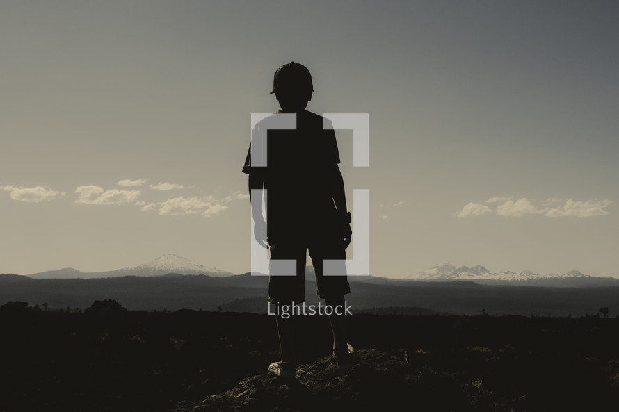 Silouette of a young boy facing forward toward mountains | Vision | Dream | Imagine | Standing