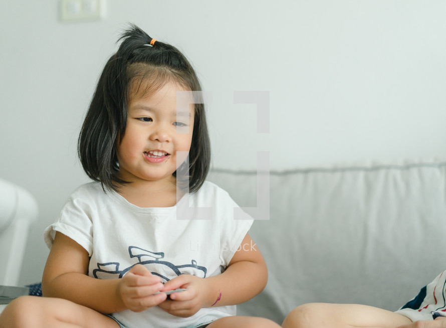 toddler girl sitting on a couch 