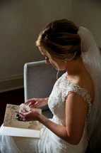 A bride holds a tissue while reading a greeting card from the groom.