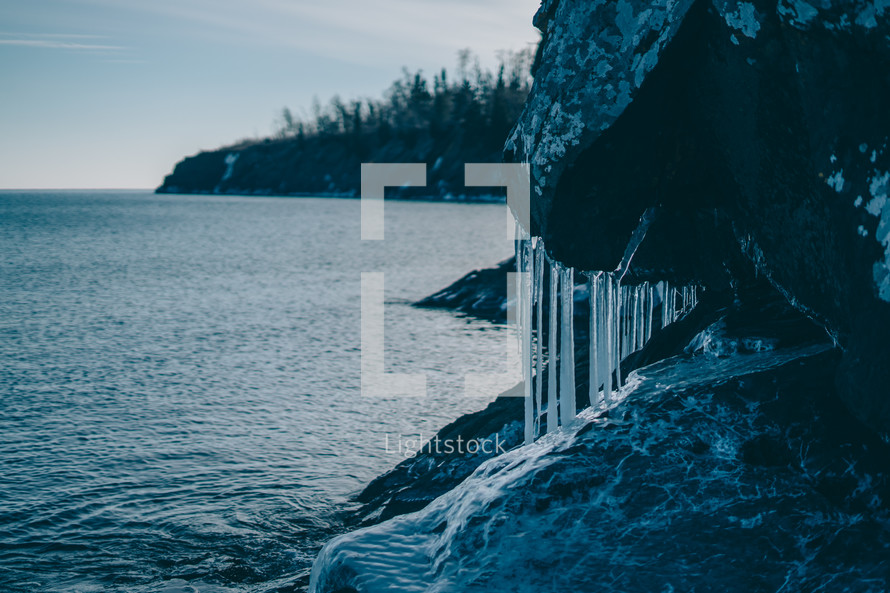 icicles on rock by a shore 