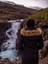 a woman looking out at a waterfall 