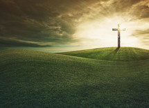 glowing cross on a grassy hill