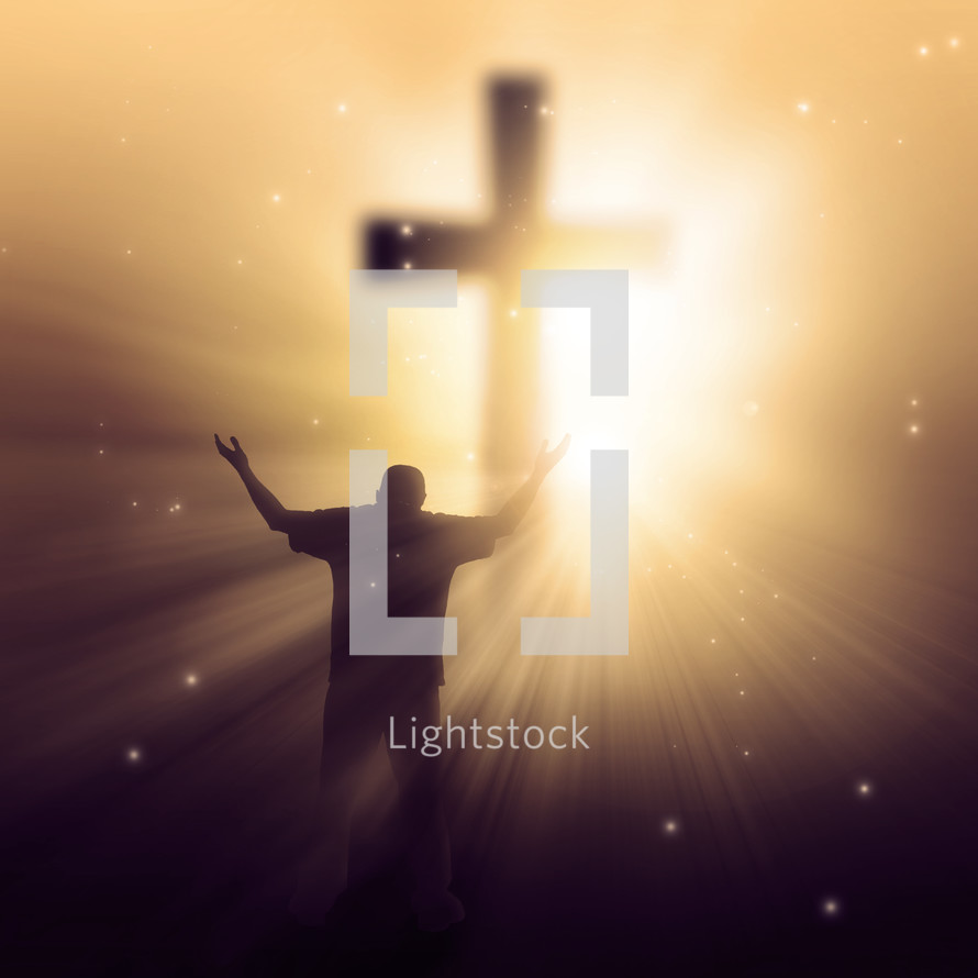 silhouette of a man in front of a glowing cross with his hands raised in praise