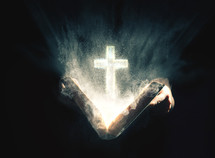 An illuminated cross rising from an open Bible.