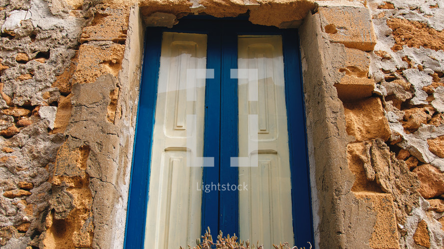 Rustic wall of house and Blue painted window of Sicily city