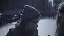 woman in a wool cap on a NYC sidewalk 