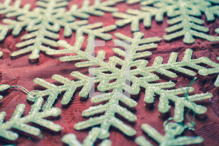 glittery snowflake ornaments on a red background 