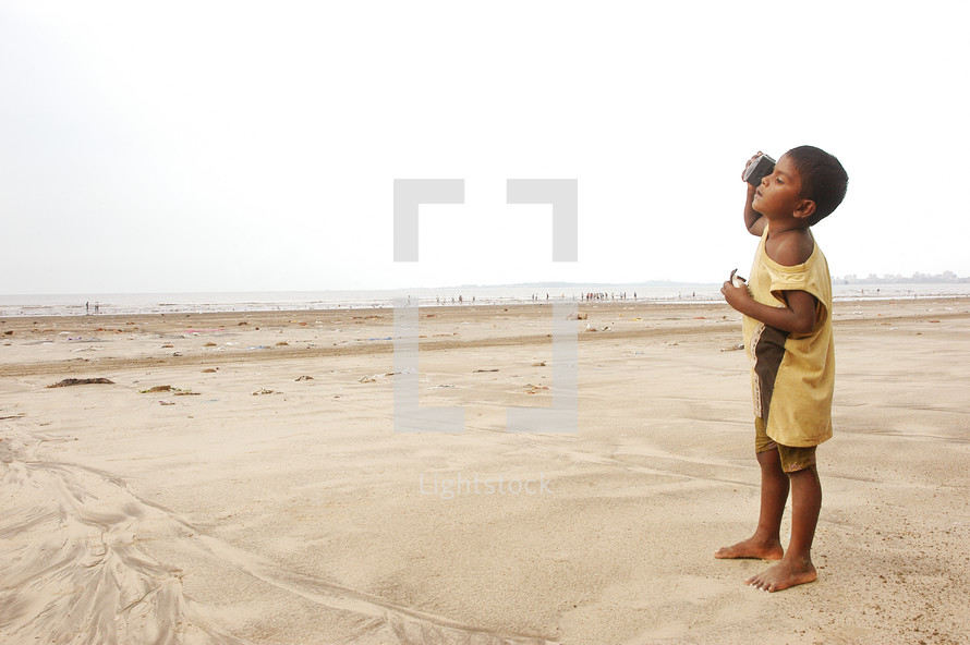 child standing barefoot on desert sand 