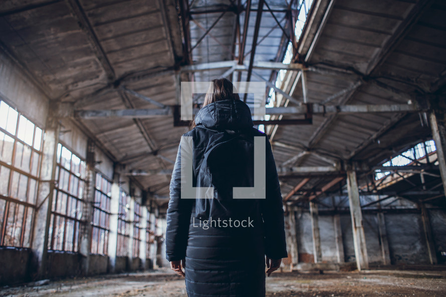 lonely girl in a black jacket in the Big Abandoned Hall