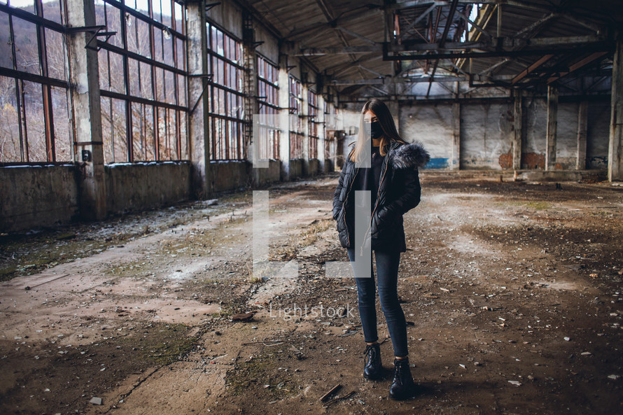 Young Girl with Mask in Empty Broken Factory Hall
